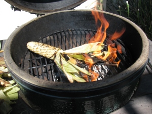 When corn husks catch fire - just let it burn off the silk and the husk - saves time later!